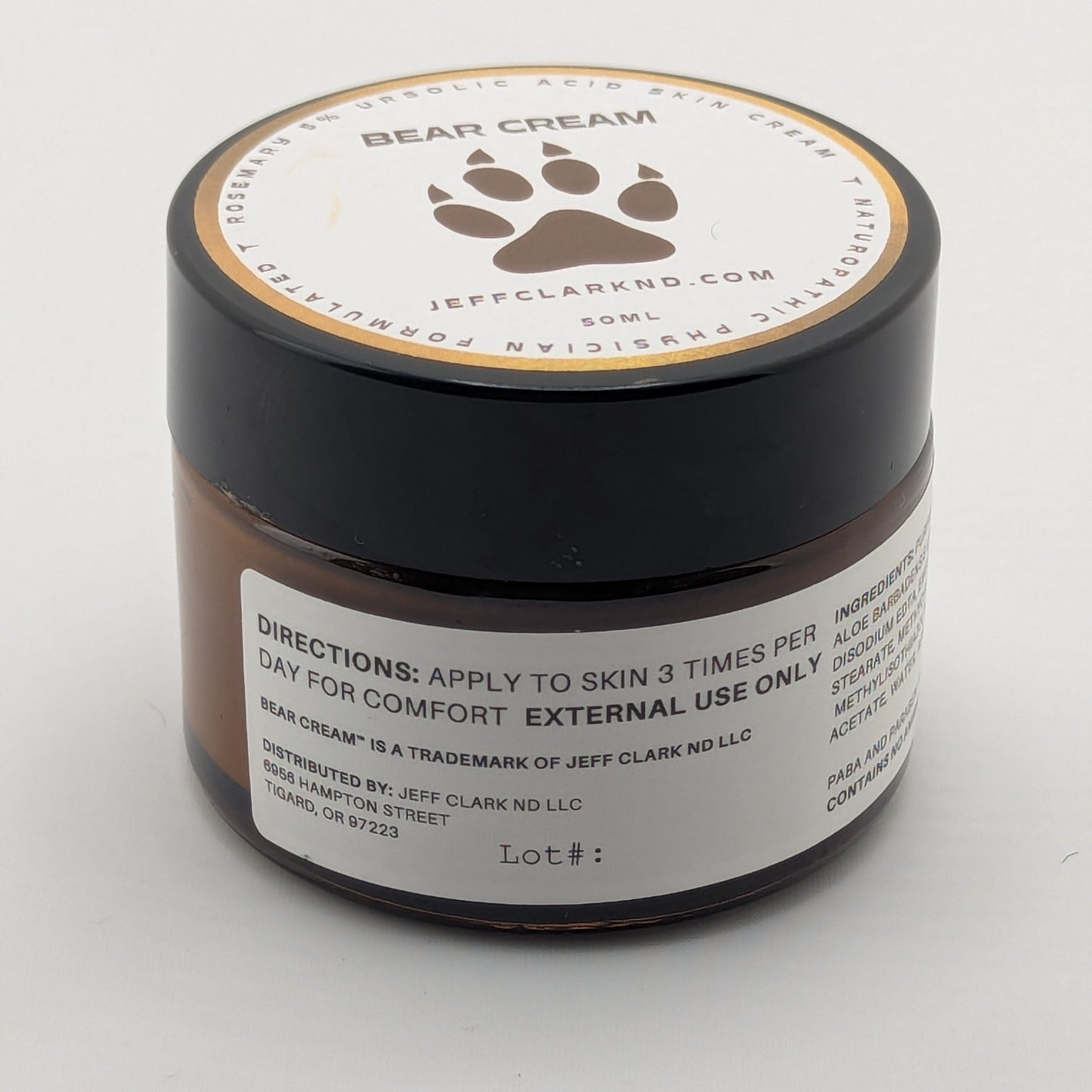Jar of bear cream with a paw print design on a white background