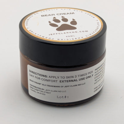 Jar of bear cream with a paw print design on a white background